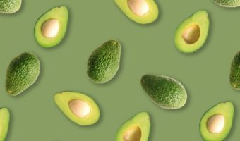 sliced avocadoes on green background