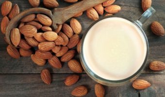 glass of almond milk and spoon of almonds