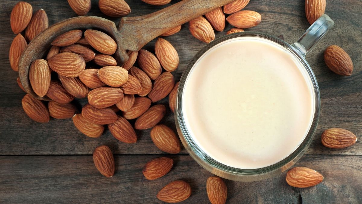 glass of almond milk and spoon of almonds