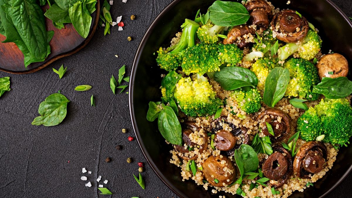 plant-based vegan salad with quinoa, spinach, broccoli, and mushrooms in a bowl